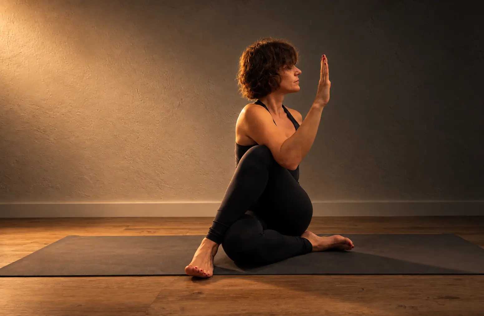 Torsión sentada de yoga terapéutico en la sala de Studio Salux